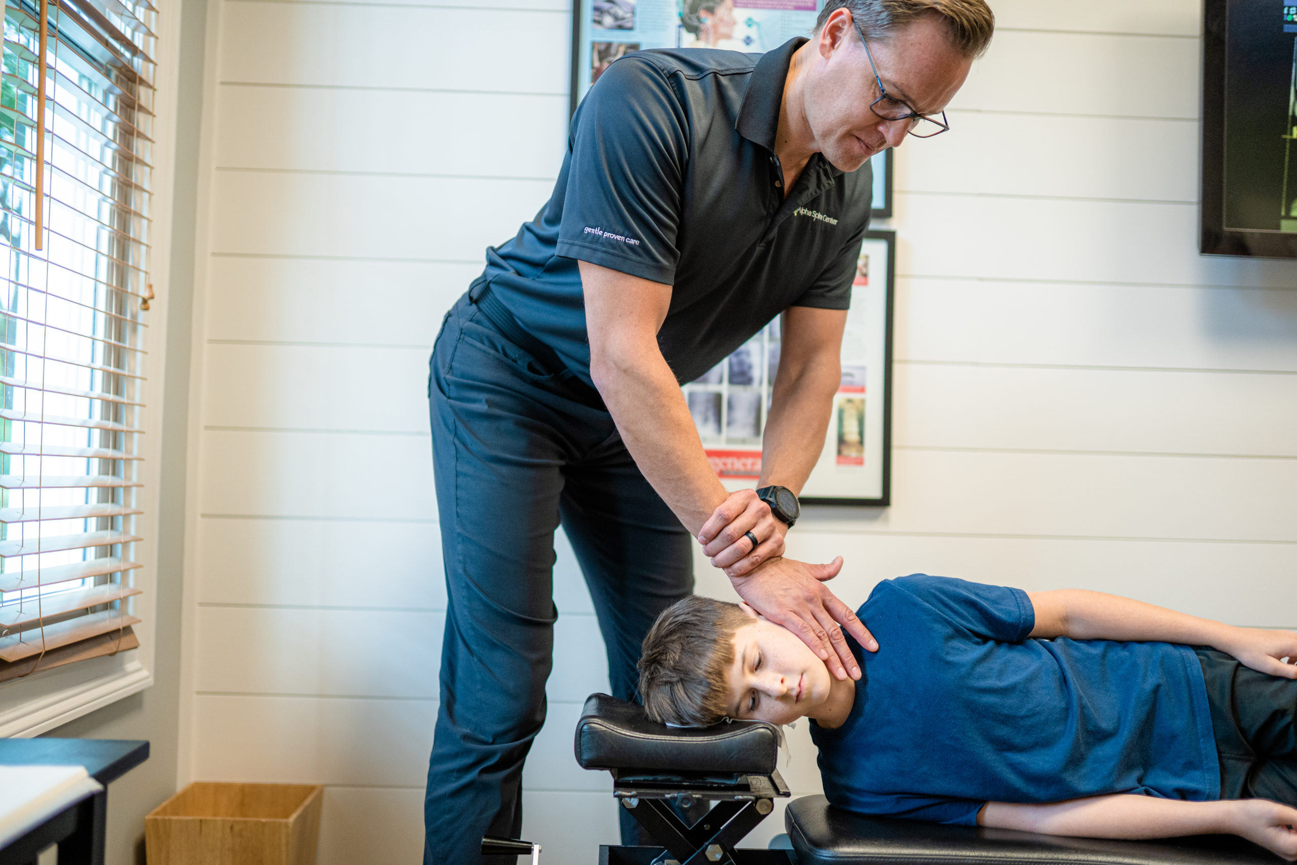 Dr. Bryan Salminen providing NUCCA care to a child at Alpha Spine Center.