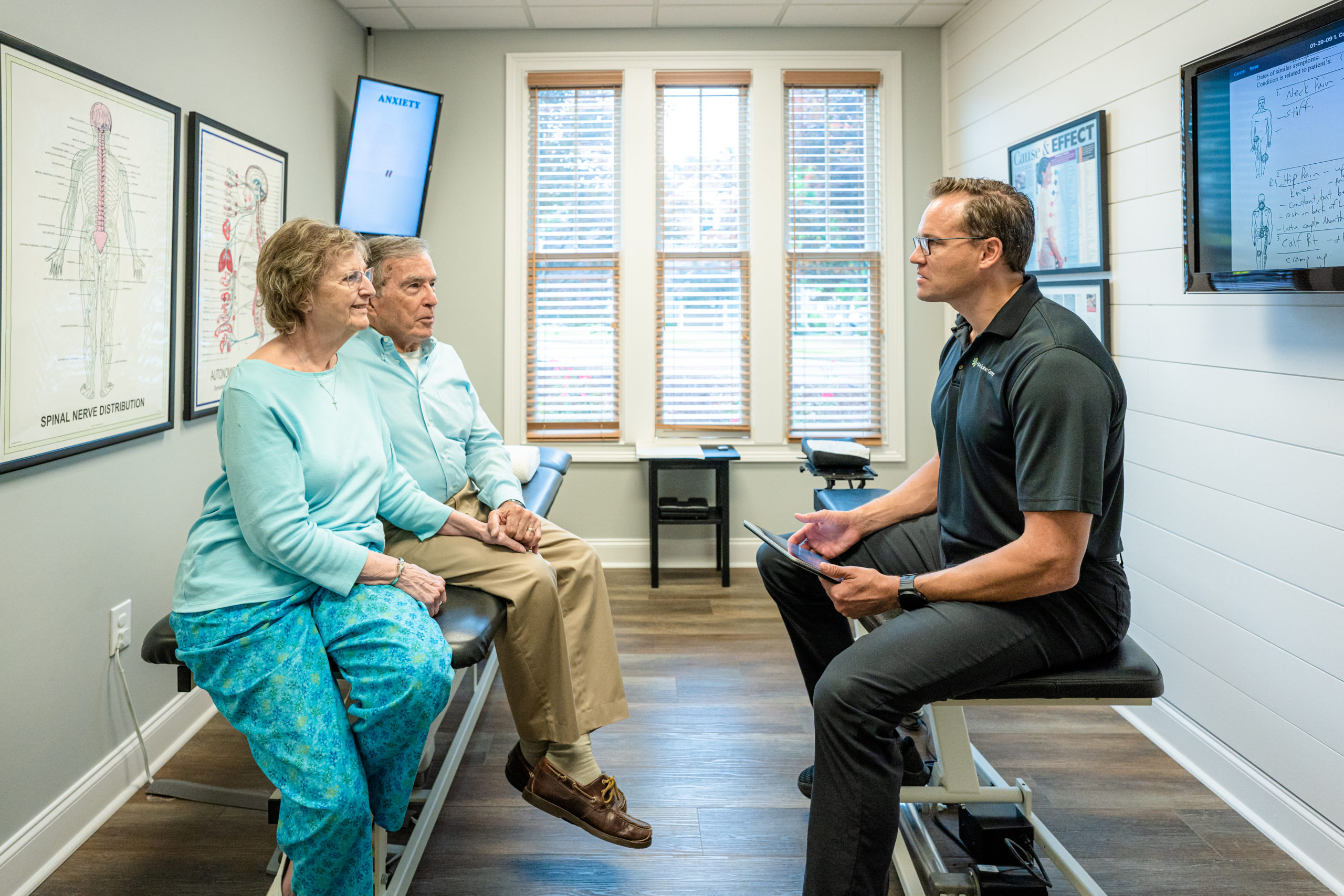 Dr. Bryan Salminen discussing care with an older couple at Alpha Spine Center.