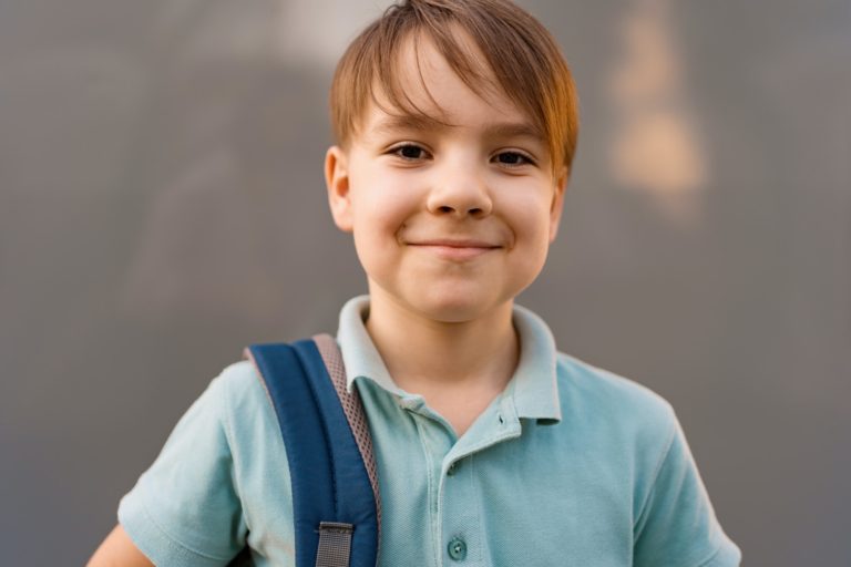 School boy posing a backpack