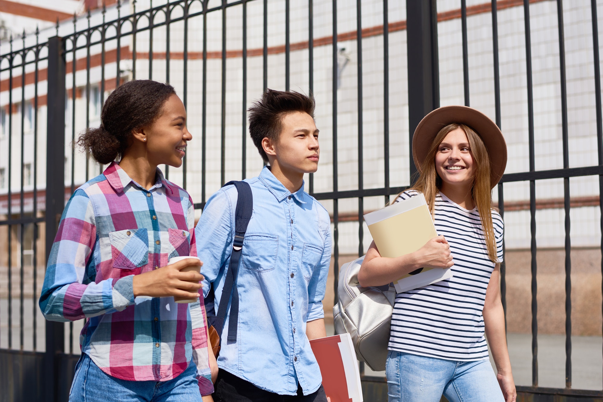 Teenagers walking together with school bags; illustrative image.