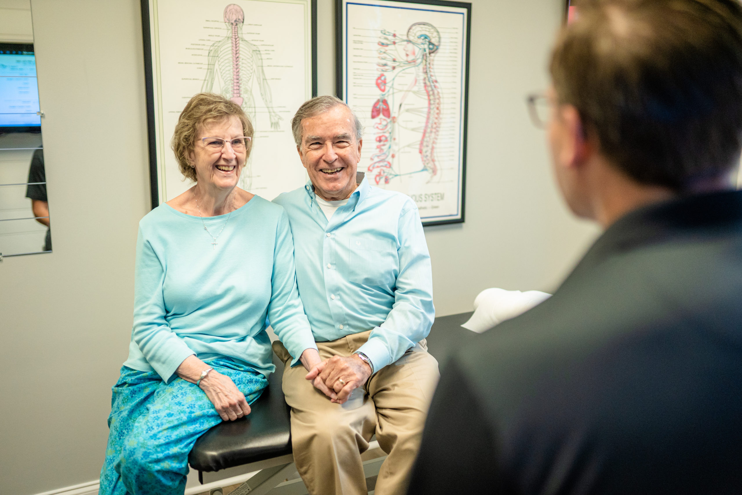 Dr. Bryan Salminen consulting with an older couple at Alpha Spine Center.