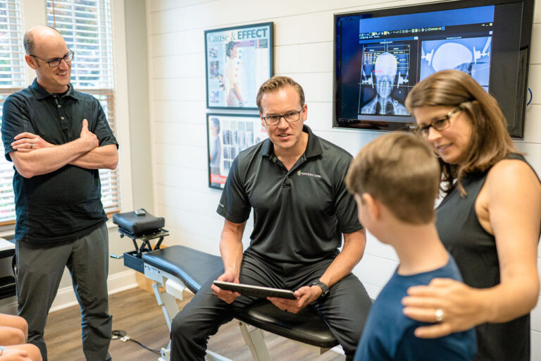 Dr. Bryan Salminen discussing a care plan with a child and family at Alpha Spine Center.
