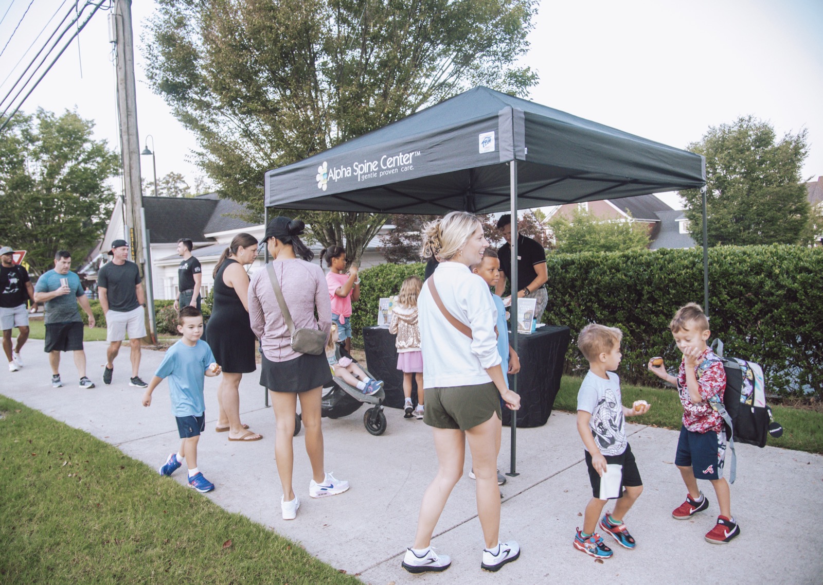 Families and children gathering at the Alpha Spine Center tent in Crabapple