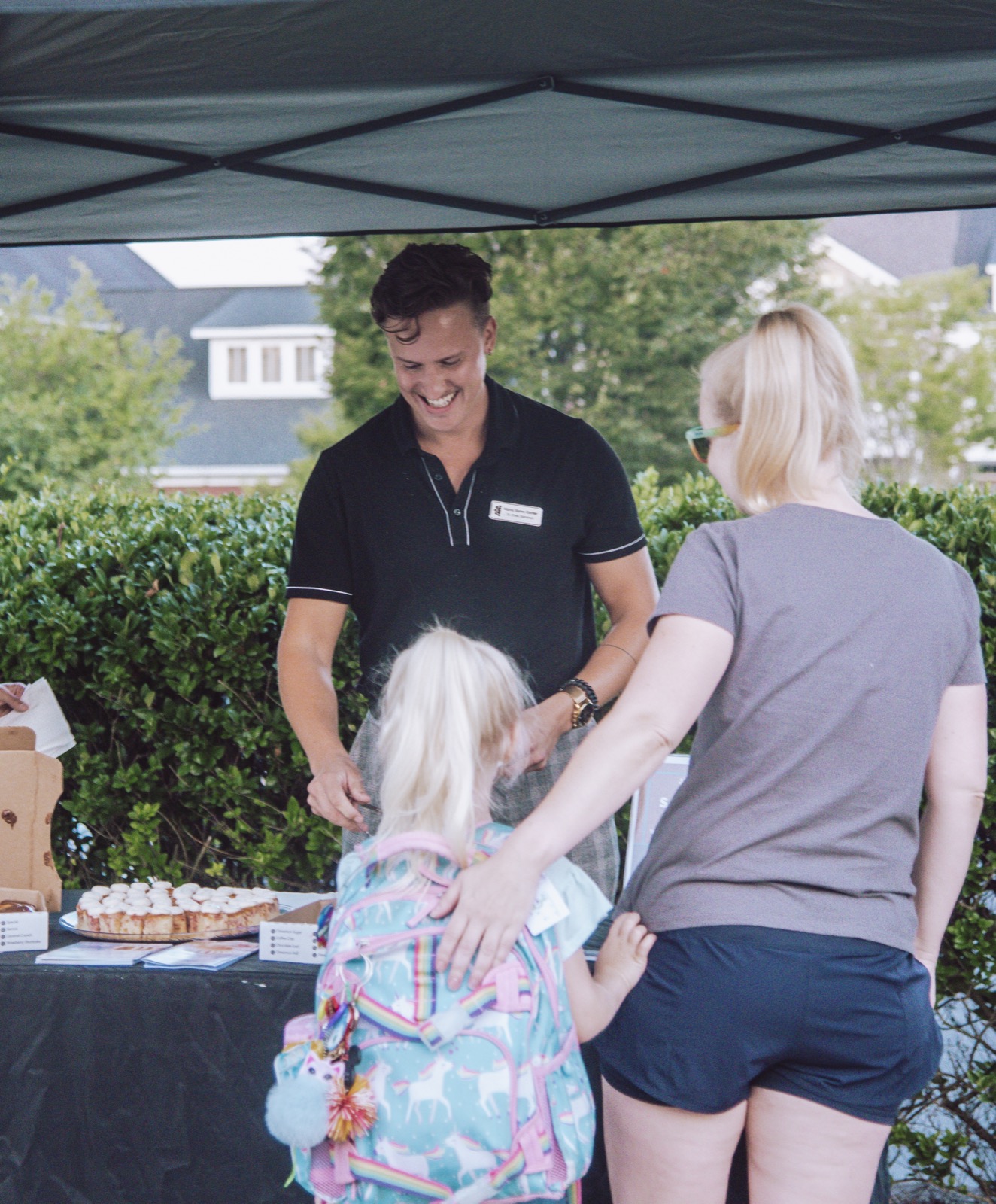 Dr. Drew smiling while welcoming a family at Walk My Kid to School Day