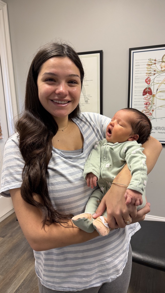 Emma holding her baby Sophie at Alpha Spine Center