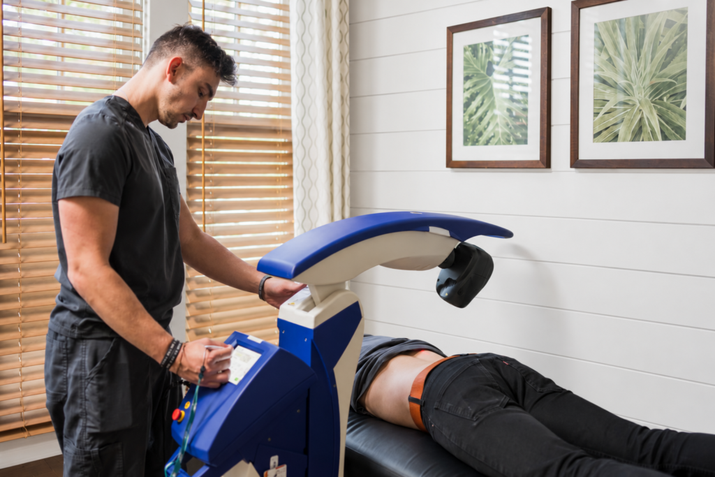 Class 4 Cold Laser Therapy with an M6 robotic laser at Alpha Spine Center in Milton; office background digitally edited.