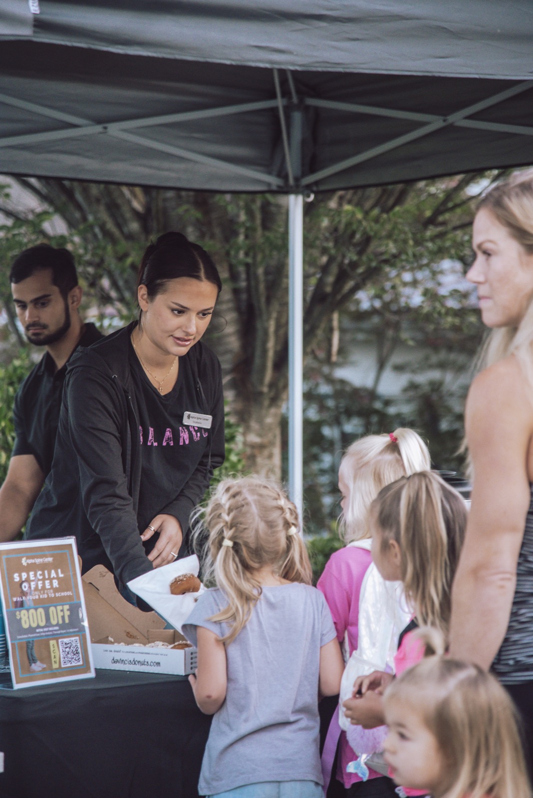 Stephanie serving donuts to children at the community event